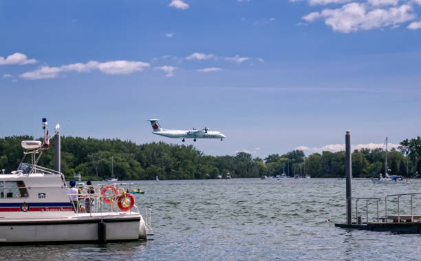 Toronto, Ontario, Canada - 2019 06 30: Air Canada turboprop aircraft descending to Billy Bishop Toronto City Airport above the waters of the Toronto Harbour. Toronto, Ontario, Canada - 2019 06 30: Air Canada turboprop aircraft descending to Billy Bishop Toronto City Airport above the waters of the Toronto Harbour airport porter stock pictures, royalty-free photos & images