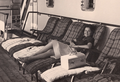 Black and White Vintage image from the 50s: Teenage girl posing sitting in a cruise deck chair in South Florida