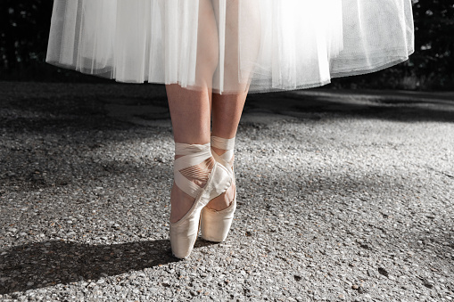 Little ballerina practicing dance moves in studio, closeup of legs. Space for text