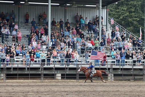 The presentation of the U.S. flag on horseback at the beginning of the rodeo