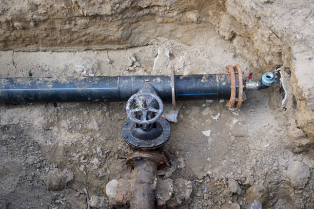 repair of urban underground communications and pipes repair of urban underground communications and pipes. in a dug trench, the junction of two pipes and an iron branch to shut off the water supply laying underground pipes stock pictures, royalty-free photos & images