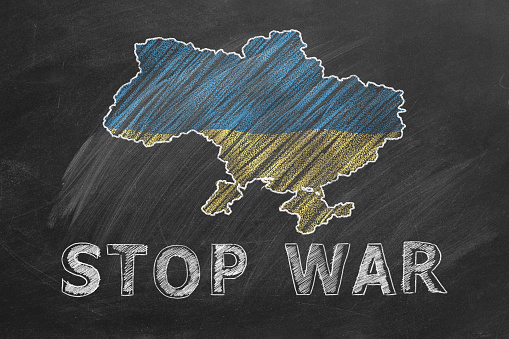 Map of Ukraine, national flag and lettering STOP WAR hand drawn with chalk on blackboard. Stand with Ukraine