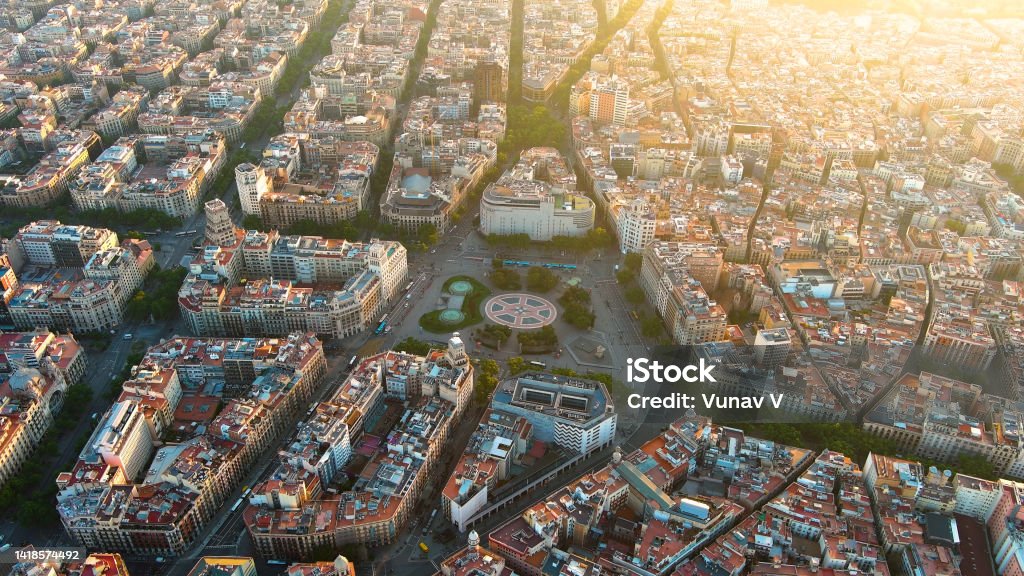 Aerial helicopter view of Plaça Catalunya in Barcelona, Spain. This square is considered to be the city center and some of the most important streets meet there Plaça de Catalunya is a large square in central Barcelona that is generally considered to be both its city centre and the place where the old city (Barri Gòtic and Raval, in Ciutat Vella) and the 19th century-built Eixample meet. Plaça de Catalunya Stock Photo
