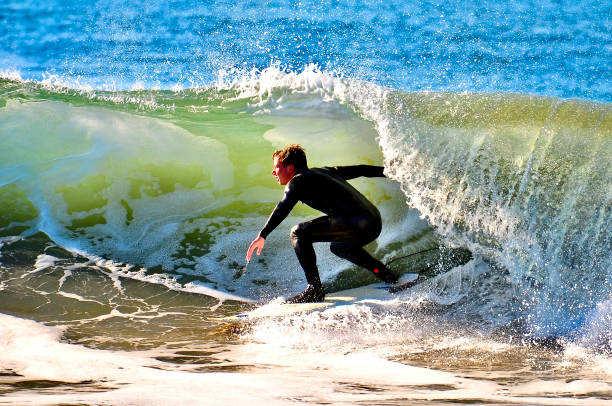 istock Surfer ducks under the lip of a sunlit wave 1418579986