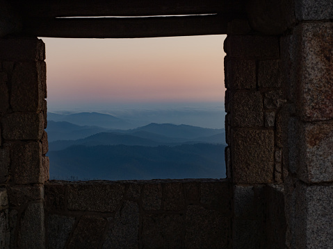 Looking at a mountain sunset view through a window