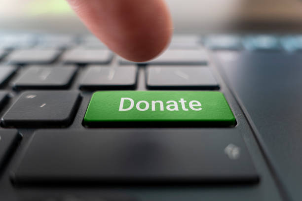 Red donate button on keyboard close-up. blurred in motion background. Red donate button on the keyboard close-up. blurred in motion background. referendum stock pictures, royalty-free photos & images