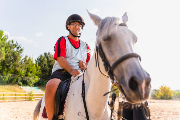 boy with down syndrome ridding   horse