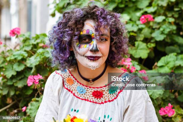 Portrait Latin Young Woman With La Calavera Catrina Makeup With Plants And Flowers In The Background Stock Photo - Download Image Now