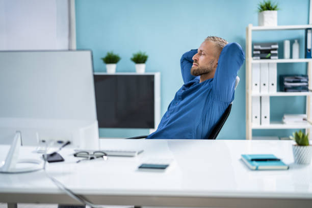 Designer relaxing with foot on the desk in a modern office