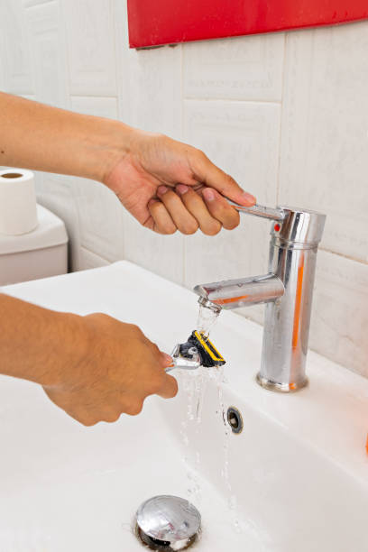 istock hands of a young man, wetting a razor 1418614203