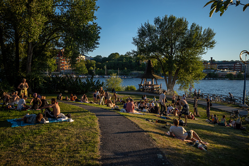 Stockholm, Sweden Aug 11, 2022 People sitting outside in the park on a summer night on the island of Reimersholme.
