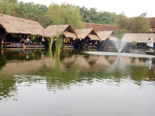 a restaurant with a traditional building on the edge of a lake in Jakarta.