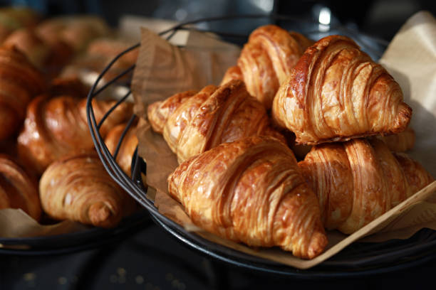 Heap of freshly baked croissants in a bakery Freshly baked croissants display on a tray in a bakery shop croissant stock pictures, royalty-free photos & images