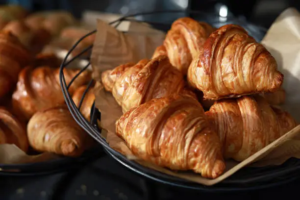 Freshly baked croissants display on a tray in a bakery shop