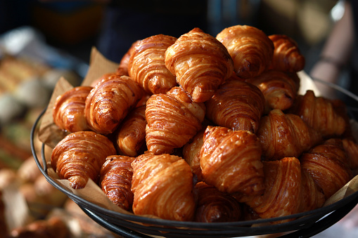 Freshly baked croissants display on a tray in a bakery shop