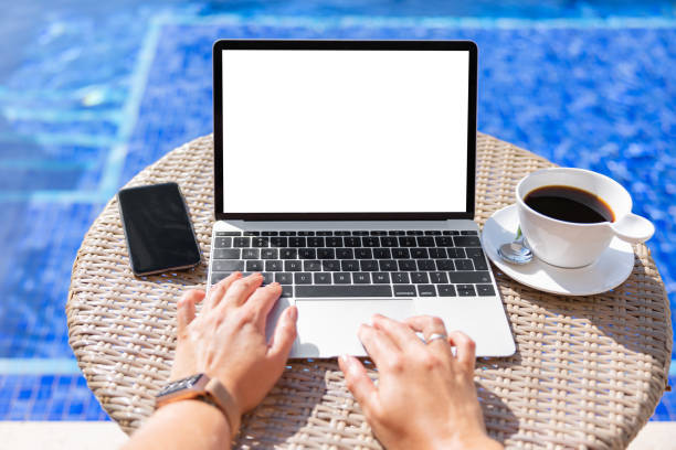 istock Woman by the pool working on laptop computer 1418649217