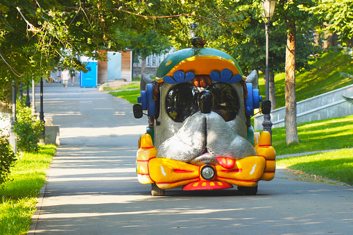Car for children in the form of a muzzle of a dog in the park. Car dog