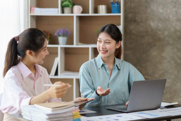 istock Two young Asian businesswomen discuss with new startup project Idea presentation, analyze planning and financial statistics and investment market on laptop computer at office. 1418651991