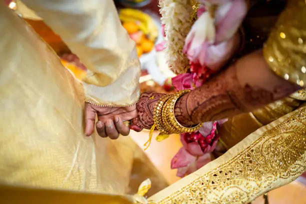 Indian couple holding hand close up in wedding ceremony
