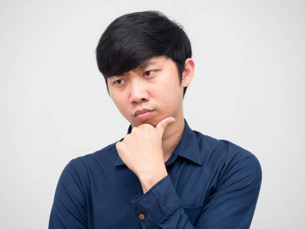 istock Closeup asian man serious face and thinking something portrait white background 1418655348