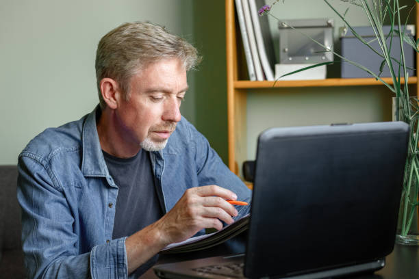 istock 50 year old bearded man working at home office 1418675475