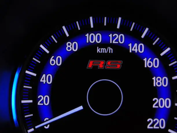 Photo of Close up blue speedometer manual in black background