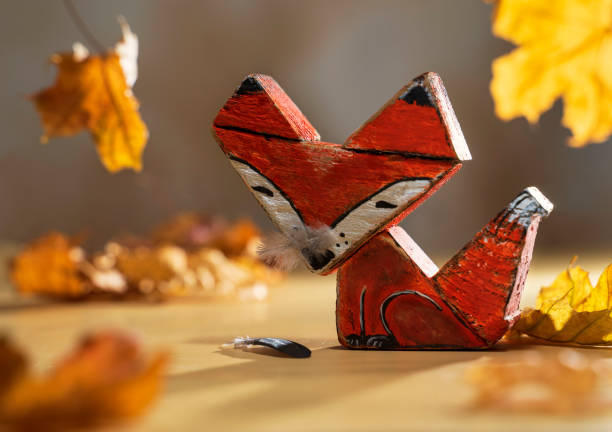istock wooden fox toy made from driftwood. Autumn composition with handicraft from a tree found on the coast and yellow leaves 1418678802