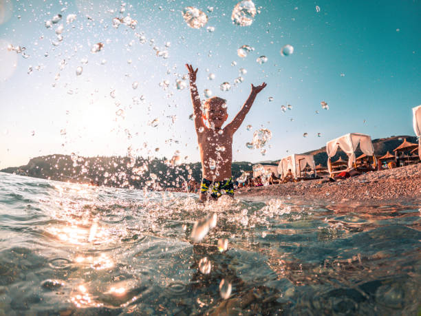 istock Happy Boy Splashing Water and Smiling 1418682365