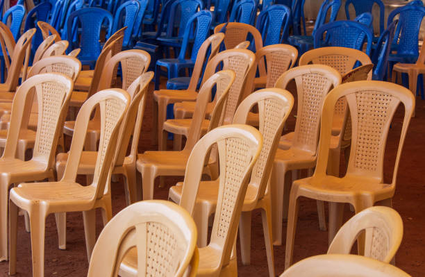 istock Plastic chairs getting organized for a public event. Chairs in an unordered way 1418689746
