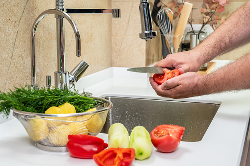 Cleaning and cutting fresh vegetables in the kitchen.