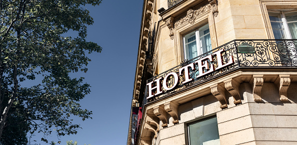Hotel sign on building facade in city, travel and accommodation concept