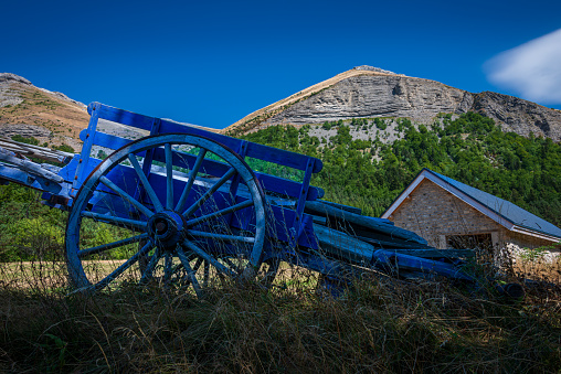 old blue wagon or cart in a field with the French alps in the background , Lus la croix haute ,France , holiday destination .