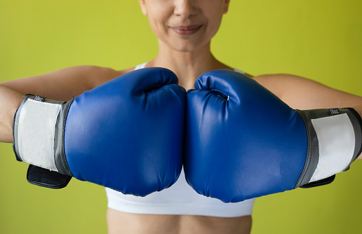 Young athletic woman having a boxing training in a gym and smiling.