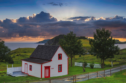 Beautiful white and red cottage in Tors Cove during sunset , Newfoundland, Canada