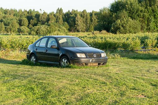 Plunge, Lithuania 9 August 2022: Old car left near billberry field.