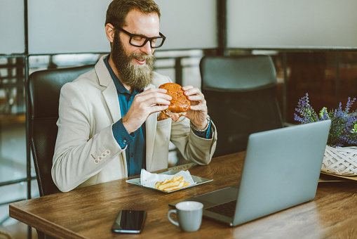 Businessman eating fast food at work