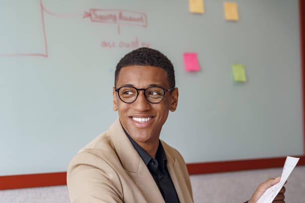 istock Busy african businessman in glasses working with documents while sitting in modern coworking 1418726742
