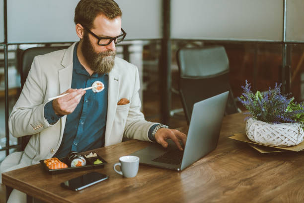 istock Businessman eating sushi in the office 1418727082