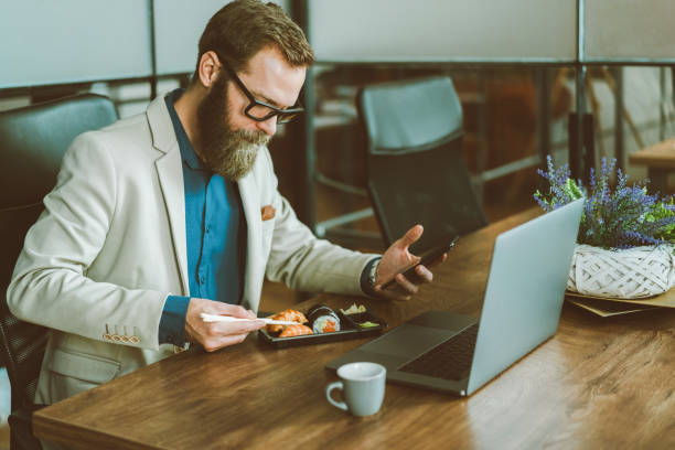 istock Businessman eating sushi in the office 1418727156