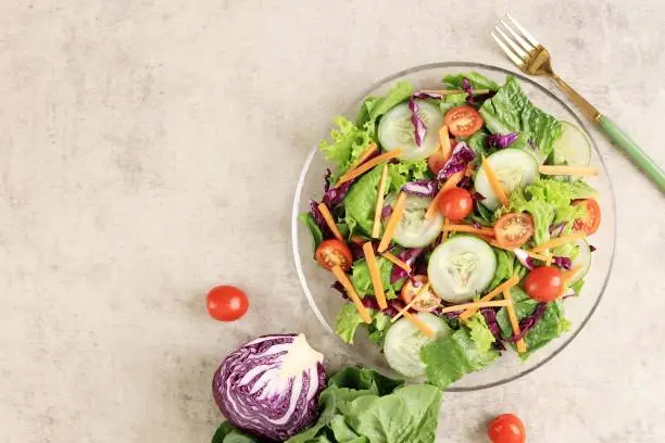 Green Vegetable Salad with Tomato, Purple Cabbage, Carrot, Cucumber, and Lettuce, Top View with Copy Space for Text
