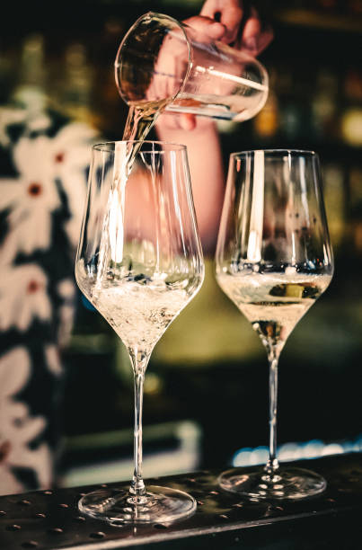 istock bartender pouring white wine into a glass in cafe or bar 1418734433