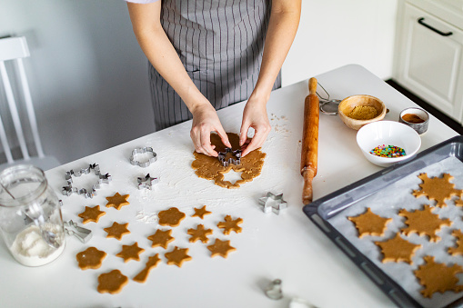 Young adult woman cooking Christmas gingerbread cookies