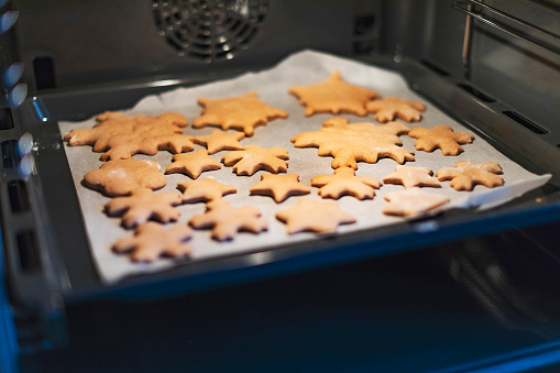 Christmas gingerbread cookies on baking pan in oven