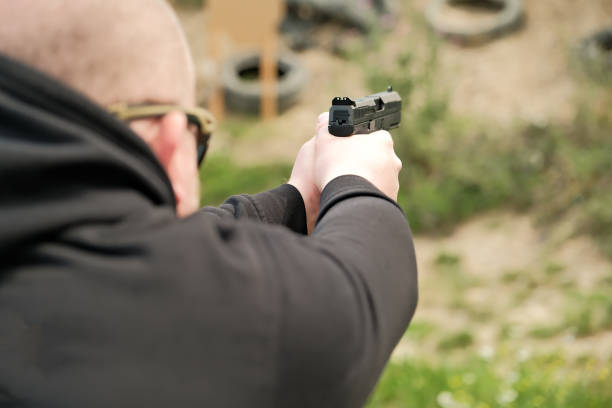 istock a man holds a gun in his hands. pistol shooting exercises 1418755433