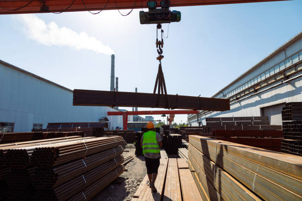 istock Worker transporting stack of metal pipes with gantry crane 1418757809