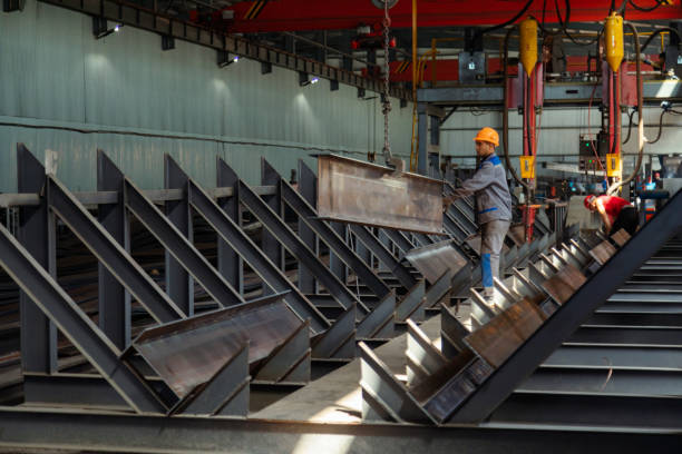 istock Worker receiving a metal bar from crane in warehouse 1418765868