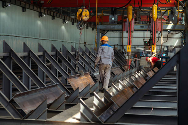 istock Worker receiving a metal bar from crane in warehouse 1418767766