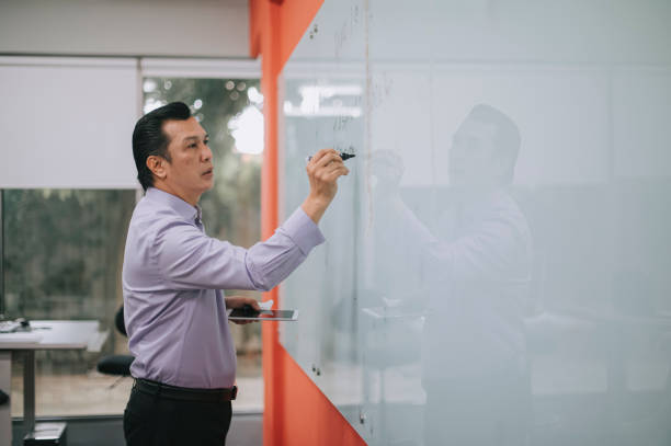 asian malay professor giving lecture writing on whiteboard in classroom explaining - concentration teacher business copy space imagens e fotografias de stock