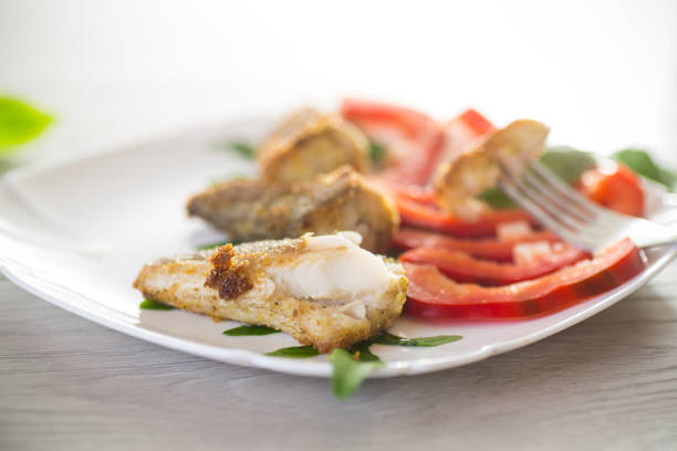 pezzi di pesce nasello fritto in un piatto con pepe - catch of fish healthy eating hake food foto e immagini stock