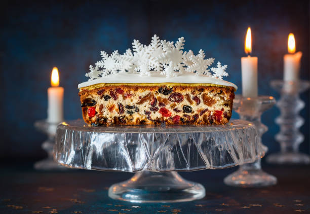 Christmas fruit cake Christmas fruit cake with icing and sugar snowflakes on the glass cake stand. marzipan stock pictures, royalty-free photos & images
